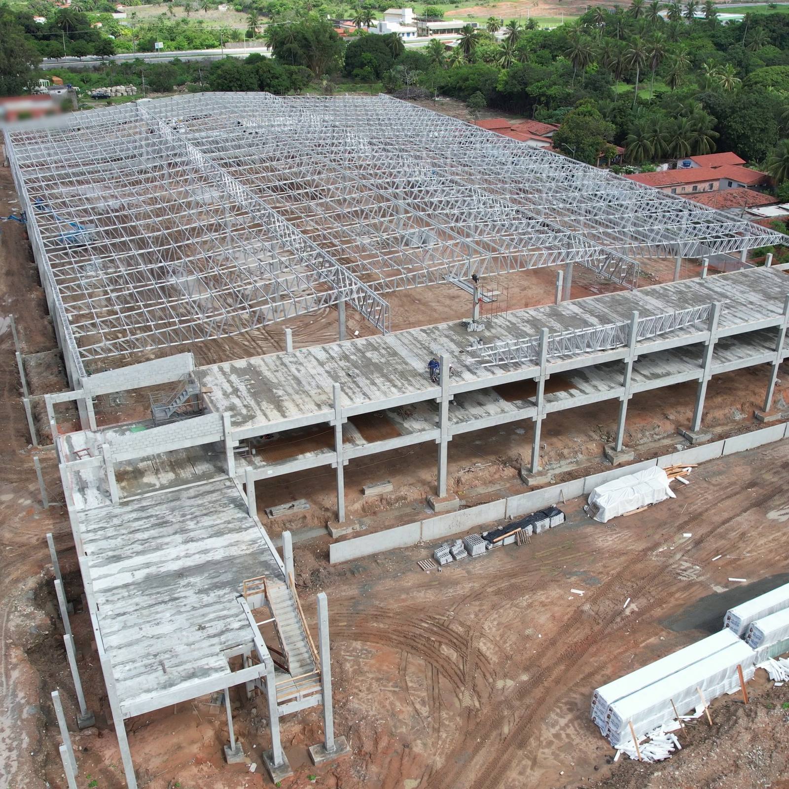 Vista aérea de estrutura pré-fabricada de concreto em montagem, com pilares, vigas e lajes